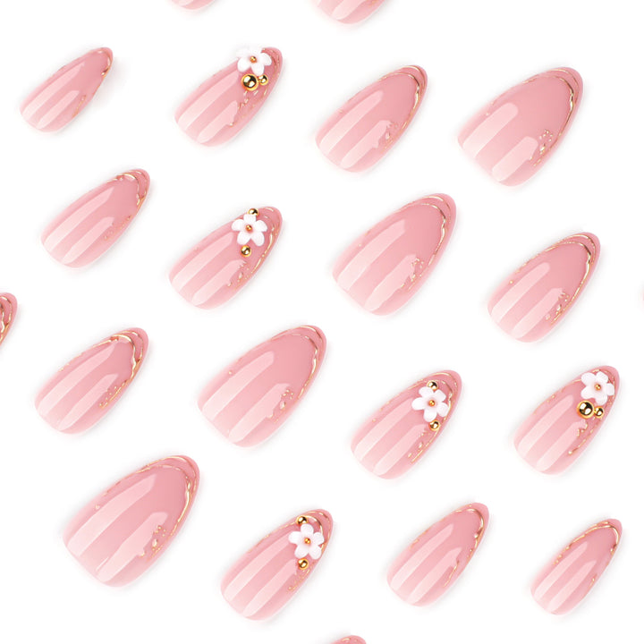 Kunstvolle Nagelgestaltung mit goldenen Akzenten und floralen Details Karnz