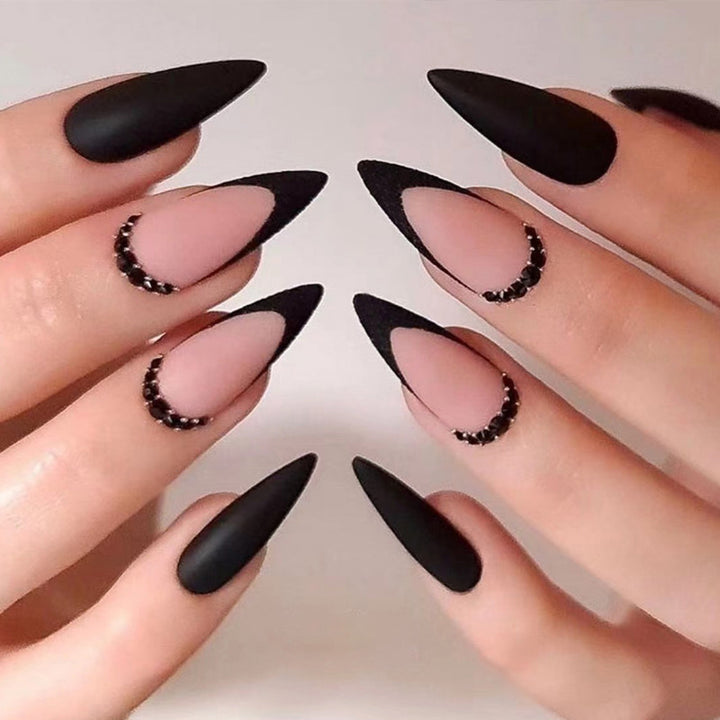 Kunstvolle Stiletto-Nägel mit elegantem Schwarz-Design und Glitzerakzenten Karnz
