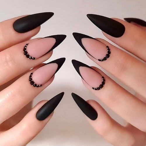Kunstvolle Stiletto-Nägel mit elegantem Schwarz-Design und Glitzerakzenten Karnz