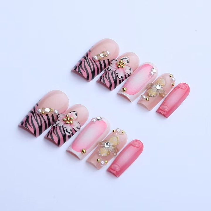 Kunstnagelset mit floralen und glamourösen Verzierungen Karnz