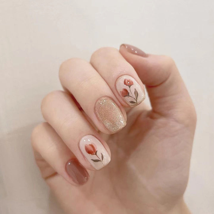 Künstliche Nail Art mit buntem Blumenmotiv und Glitzerakzenten Karnz