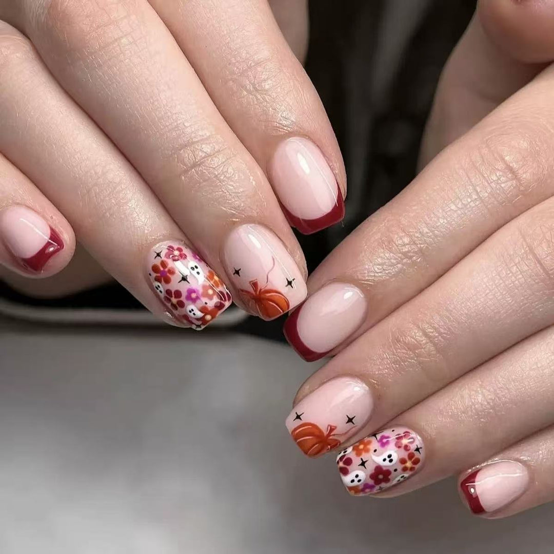 Kunstnagelset mit fröhlichen Blumenmotiven und eleganten French-Spitzen Karnz