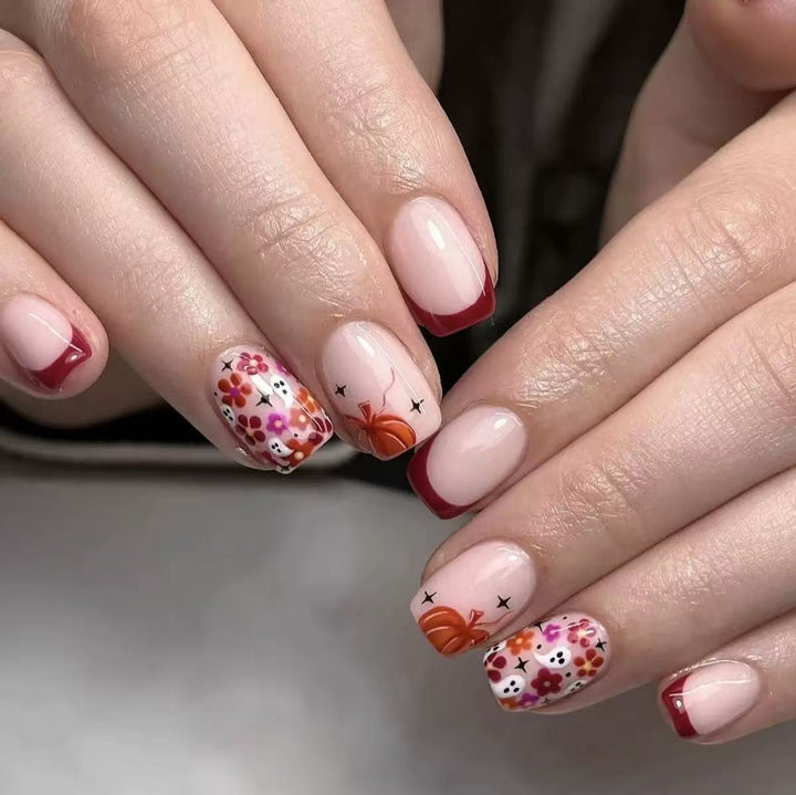 Kunstnagelset mit fröhlichen Blumenmotiven und eleganten French-Spitzen Karnz