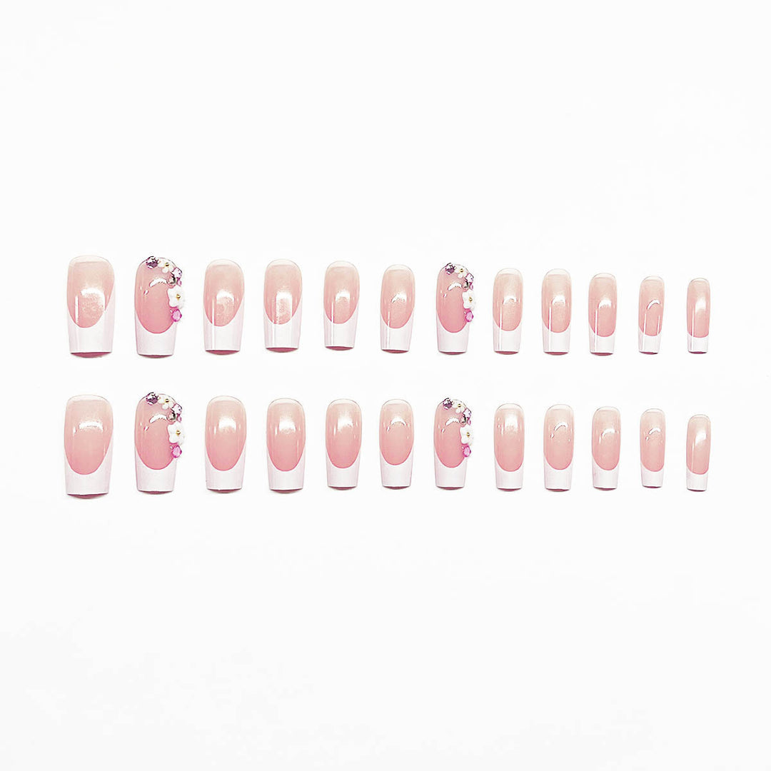 Kunstnagelset mit eleganten Blumendekoren und transparentem Finish Karnz
