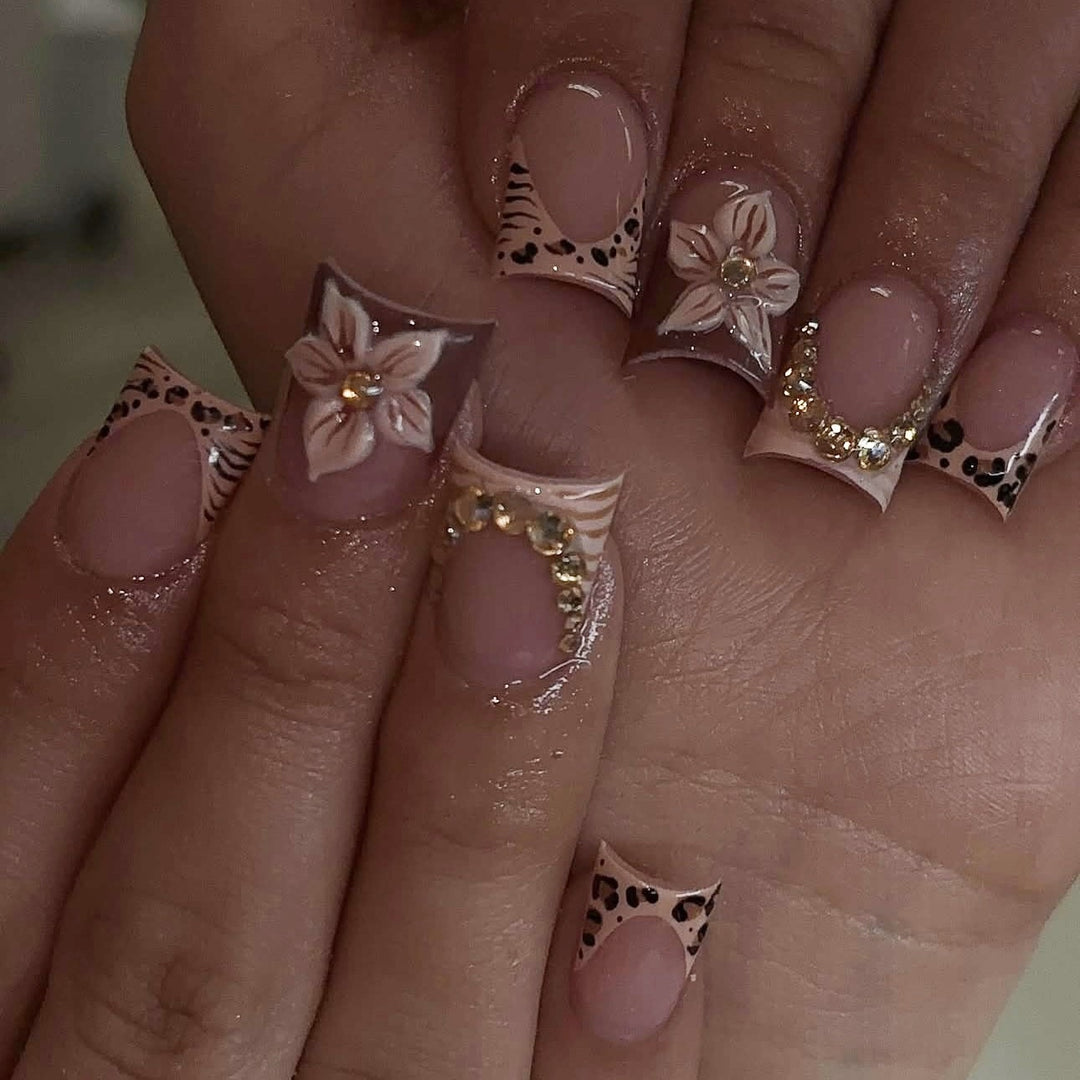 Kunstnagelset mit floralen Verzierungen und eleganten Glitzerdetails Karnz