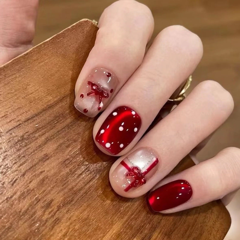 Kunstnagelset mit festlichem Geschenk-Design und eleganten Glitzer-Akzenten Karnz