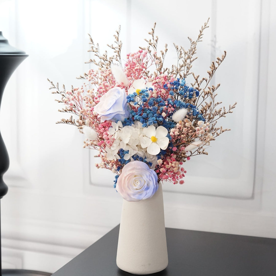 Künstliches Blumenarrangement mit dekorativer Vase
