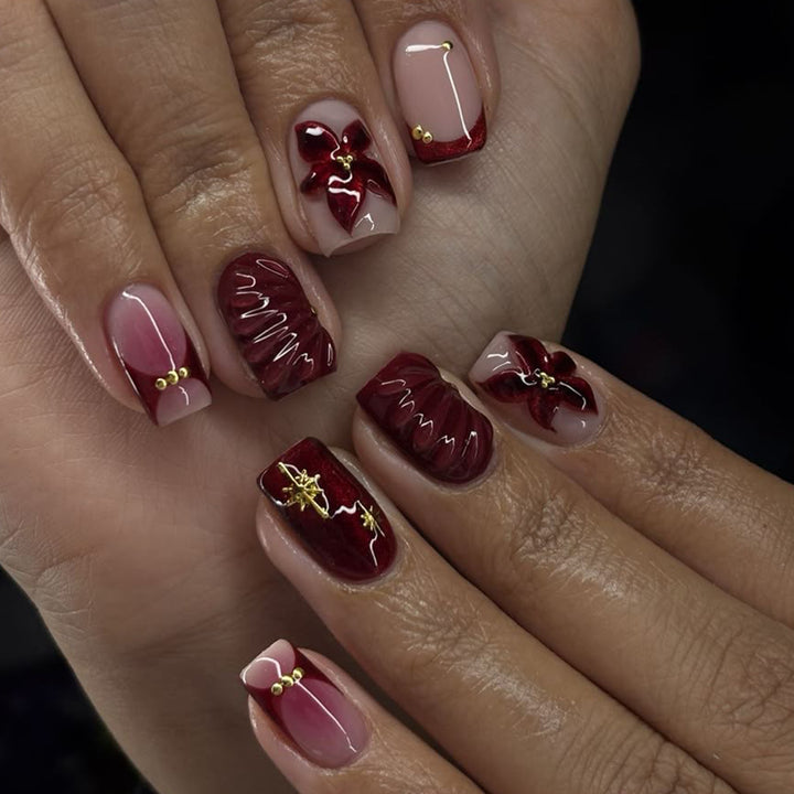 Kunstvolle Nagelgestaltung mit floralen und goldenen Akzenten Karnz