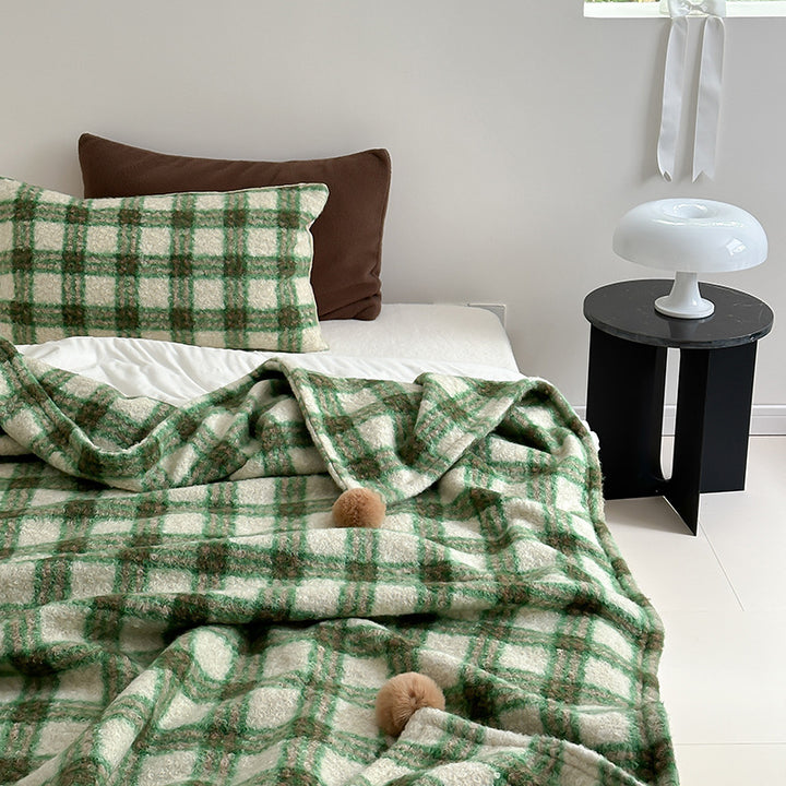 Kuscheldecke mit kariertem Muster und Bommelverzierung Karnz