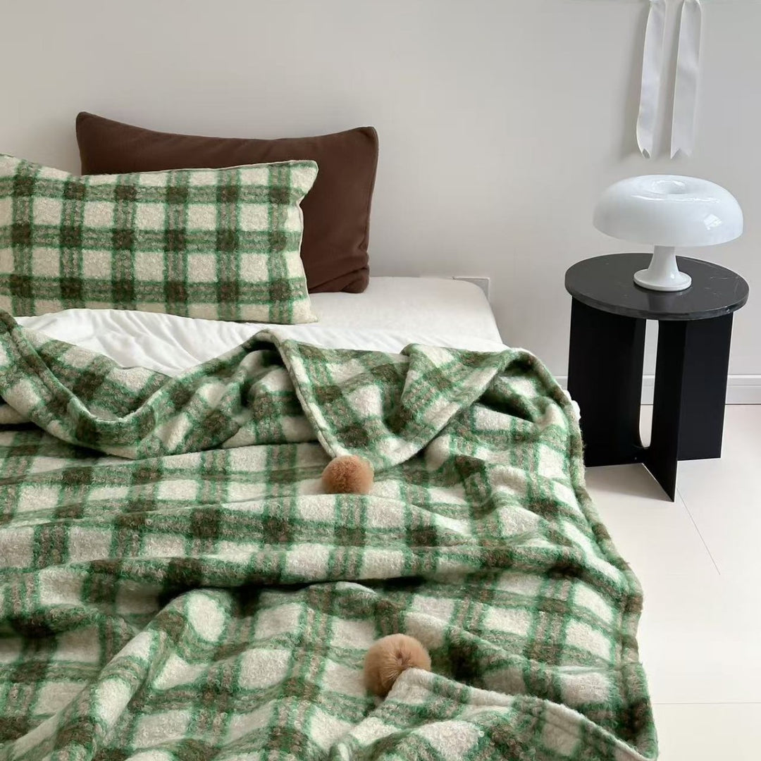 Kuscheldecke mit kariertem Muster und Bommelverzierung Karnz