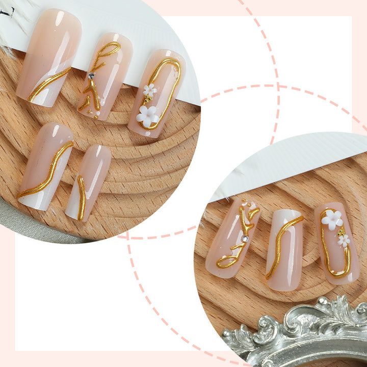 Elegantes Kunstnagelset mit goldenen Akzenten und floralen Details Karnz
