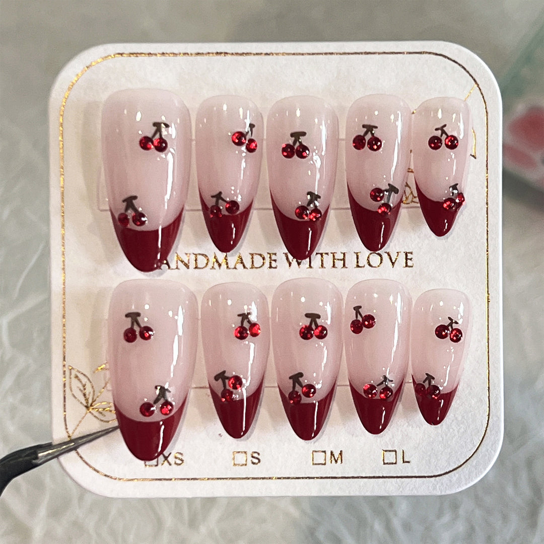 Kunstvolle Stiletto-Nägel mit Kirschmotiven und Glitzerakzenten Karnz
