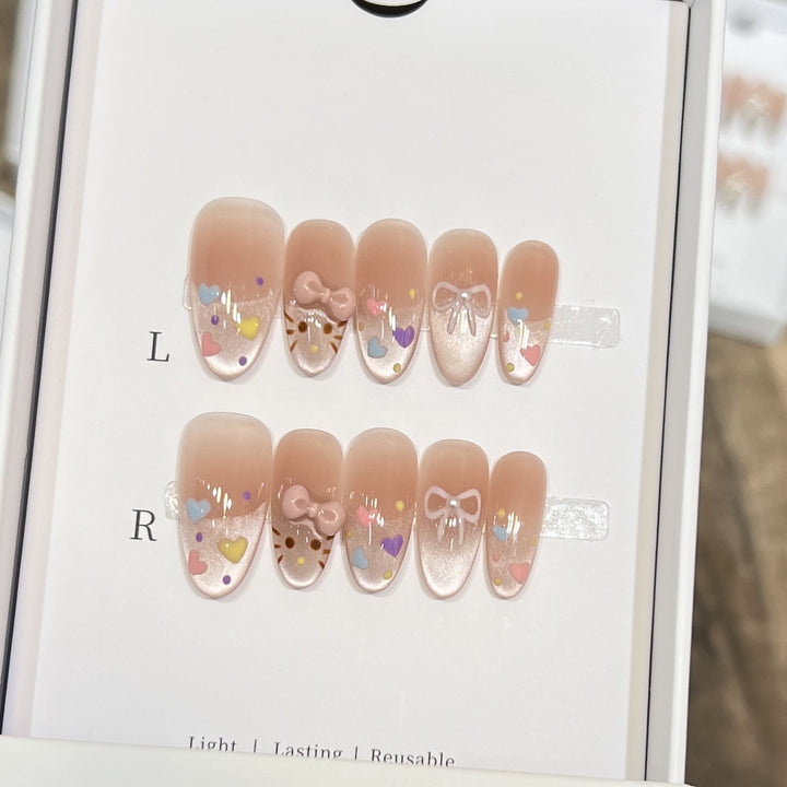 Dekorativer Press-On Nail Set mit bunten Herz- und Schleifendekoren Karnz