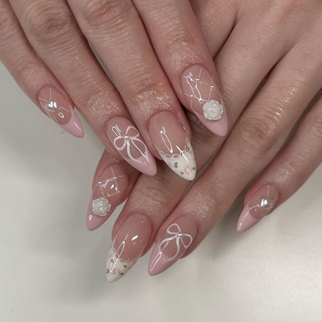 Kunstvolle Nagelkunst mit floralen Details und Schleifenverzierungen Karnz