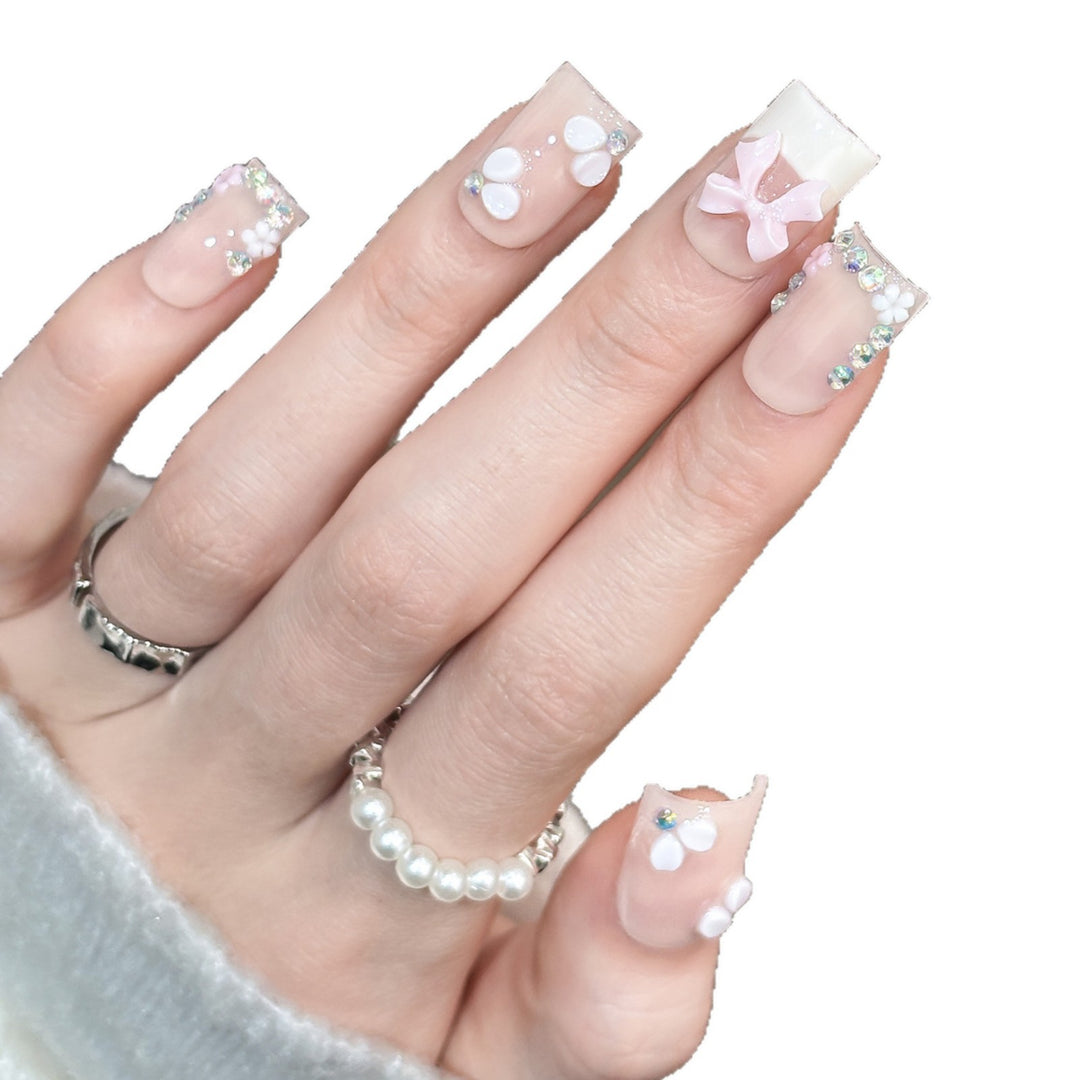 Dekoratives Nagelkunstset mit floralen Details und Schleifenakzenten