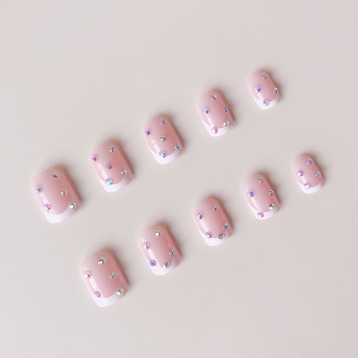 Elegantes Kunstnagelset mit funkelnden Strassverzierungen Karnz