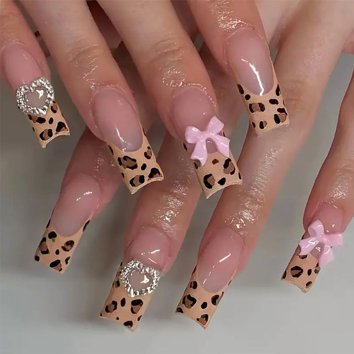 Kreatives Nagelset mit Leopardenmuster und Schleifenakzenten Karnz