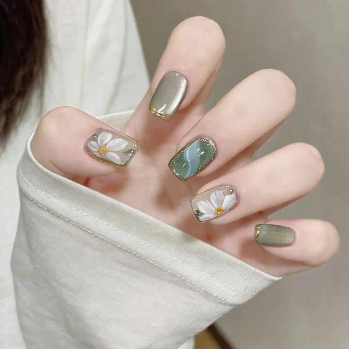 Kunstnägel mit Floralen Akzenten und Glamourösem Goldrand Karnz