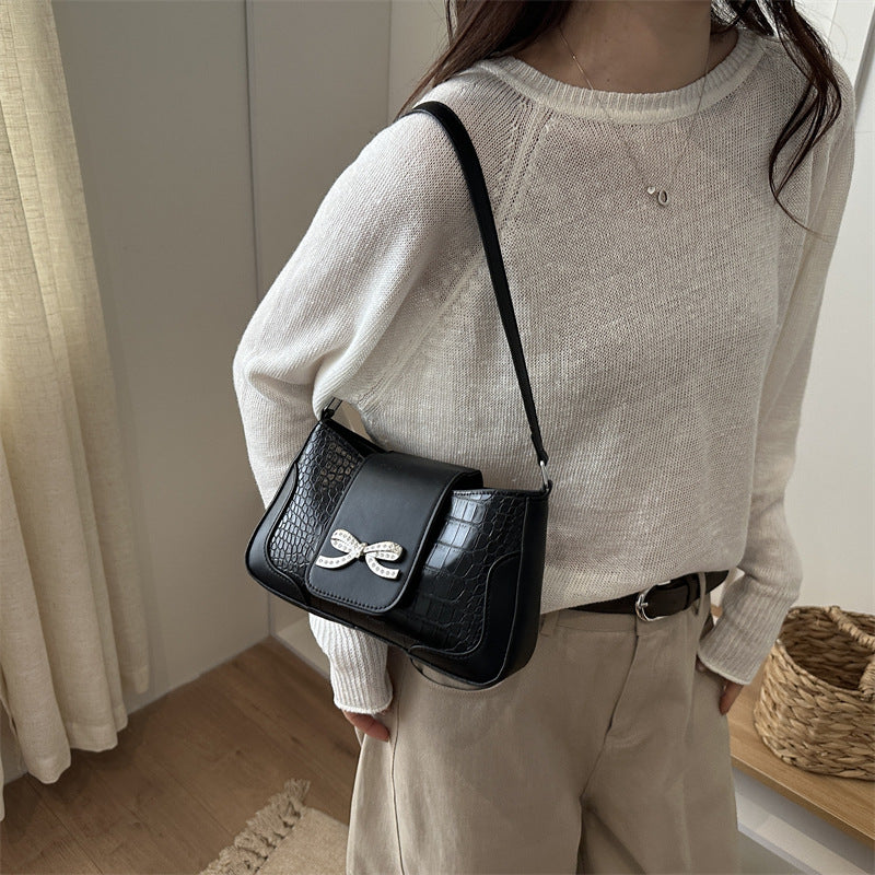 Elegante Handtasche mit Krokodilmuster und Schleifendetail