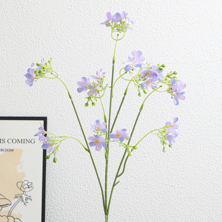 Künstlicher Blütenzweig mit zarten blauen Blumen und grünen Beeren Karnz