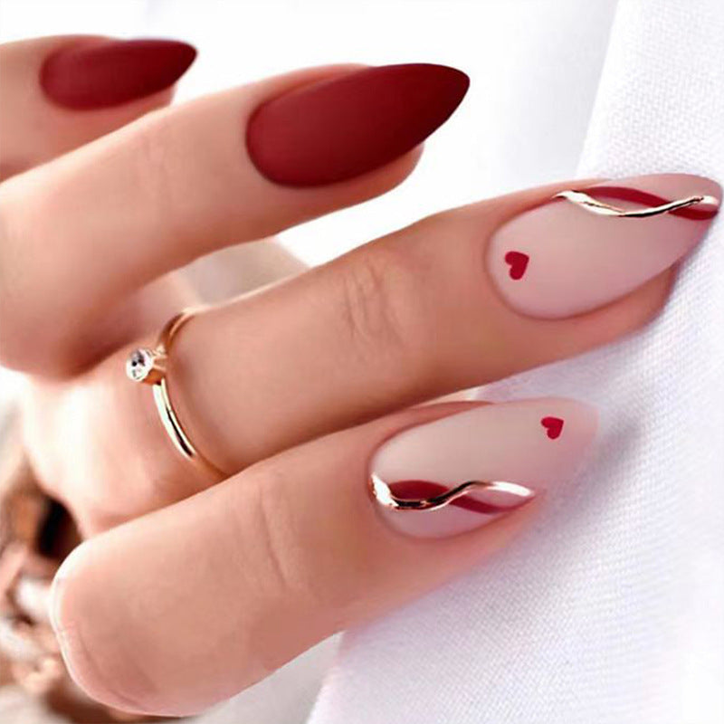 Kunstvolle Stiletto-Nägel mit herzförmigen Akzenten Karnz