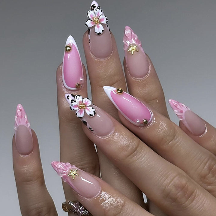 Kunstvolle Nagelverlängerungen mit floralen Akzenten und Glitzer Karnz