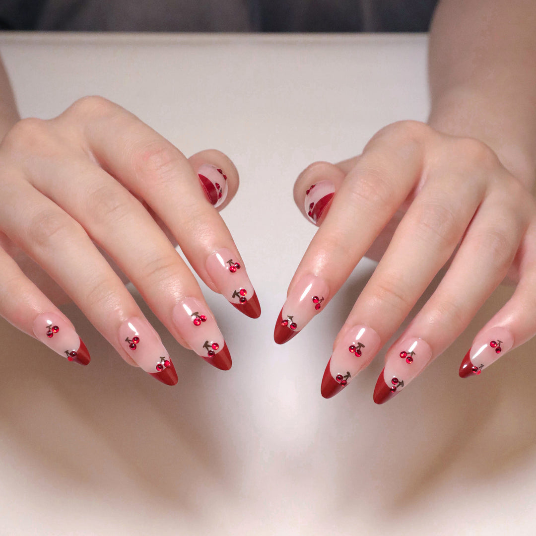 Kunstvolle Stiletto-Nägel mit Kirschmotiven und Glitzerakzenten Karnz
