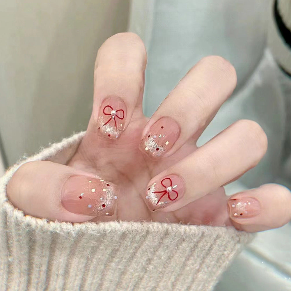Künstliche Nagelkunst mit eleganten Schleifen und Glitzerakzenten Karnz