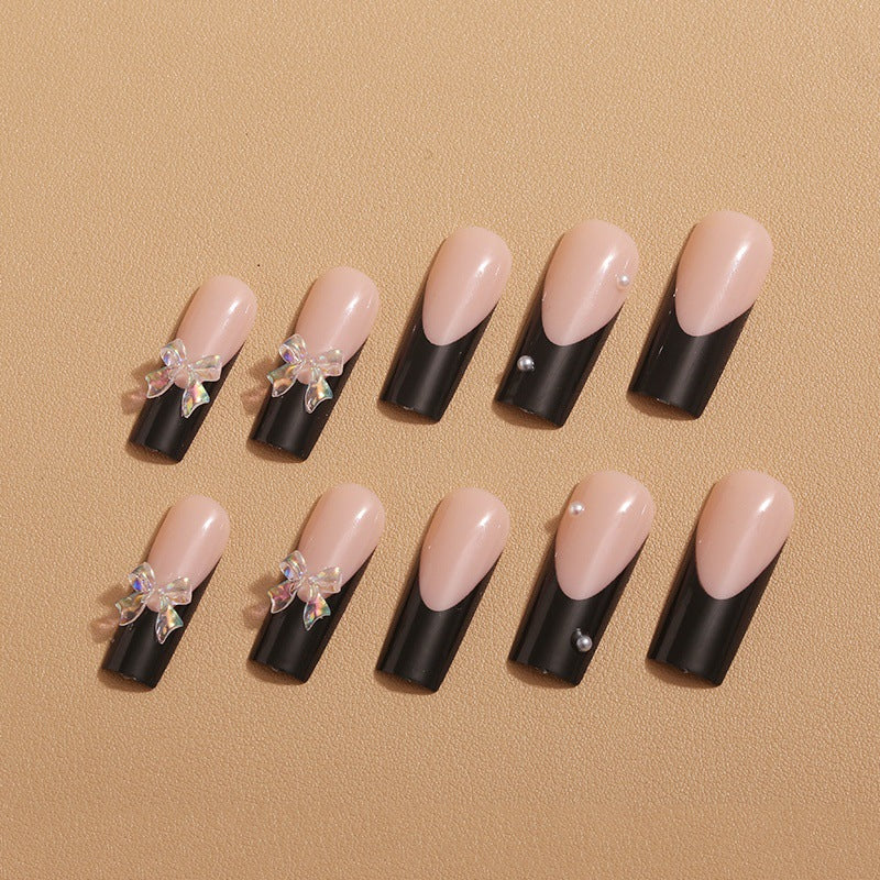 Kunstnagelverzierung mit eleganten Schleifen und Strass Karnz