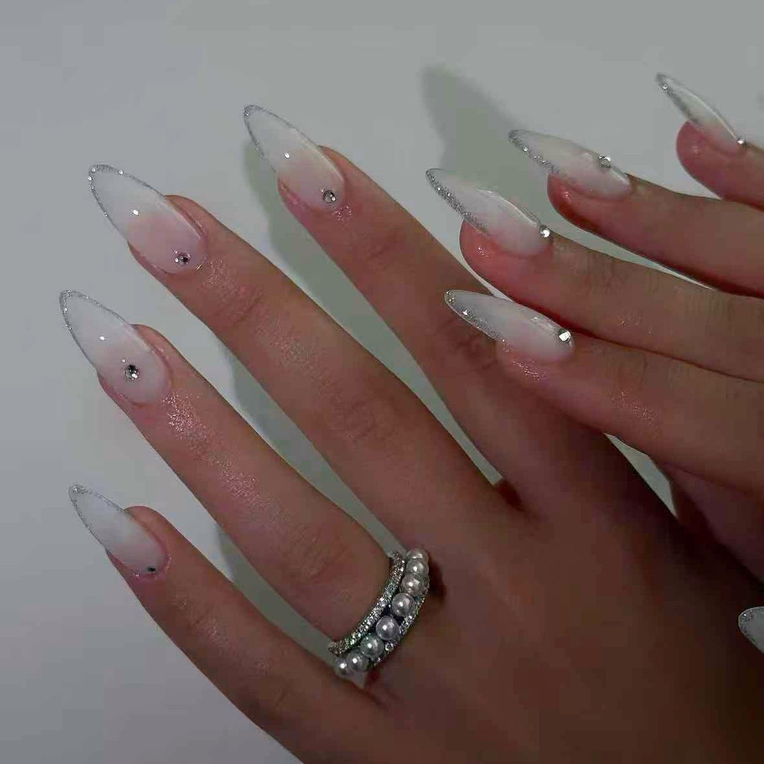 Kunstnagelset mit eleganten Spitzen und funkelnden Akzenten Karnz