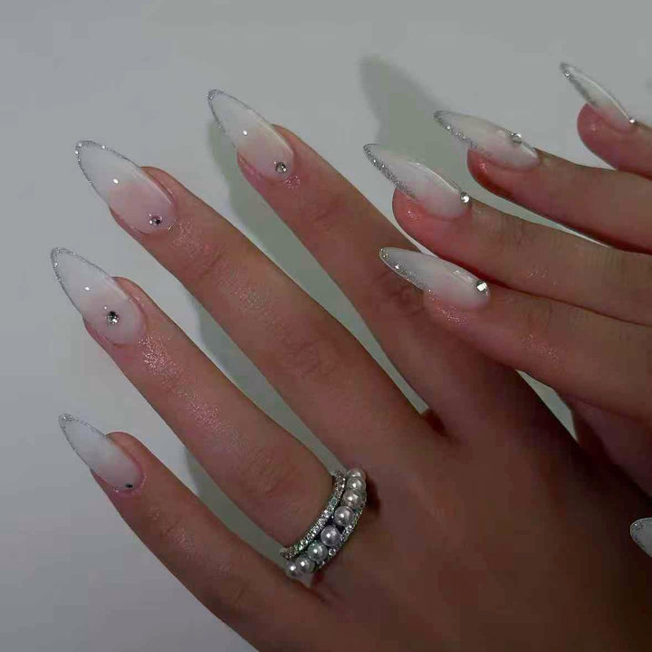 Kunstnagelset mit eleganten Spitzen und funkelnden Akzenten Karnz