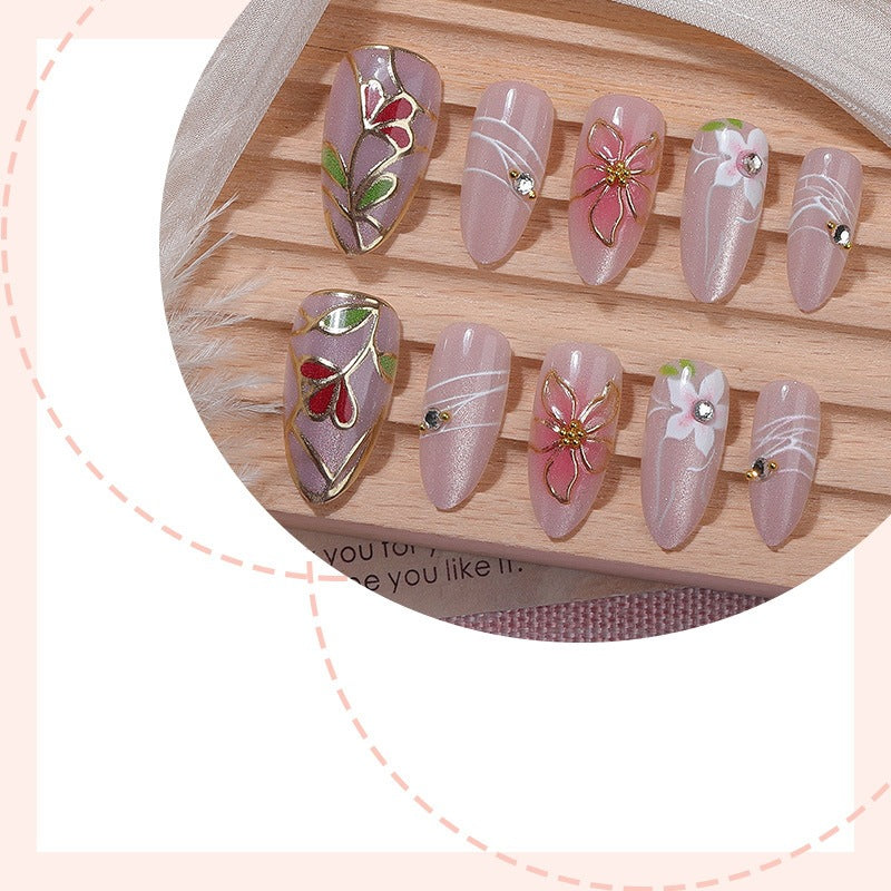 Kunstnagelset mit filigranen floralen Verzierungen und glänzenden Details Karnz