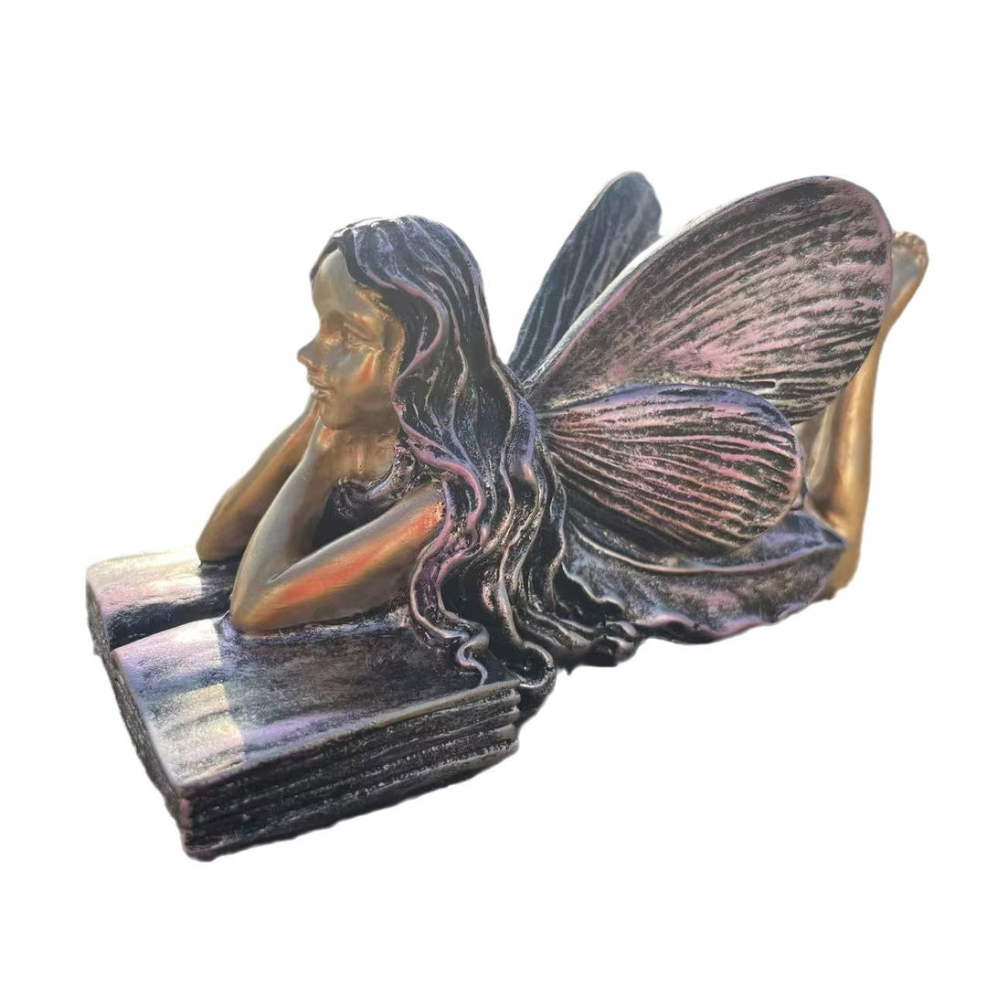 Feenfigurine, die auf Büchern sitzt, Karnz
