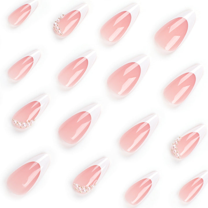 Kunstnagelset mit eleganter French Spitze und perlenverzierten Akzenten Karnz