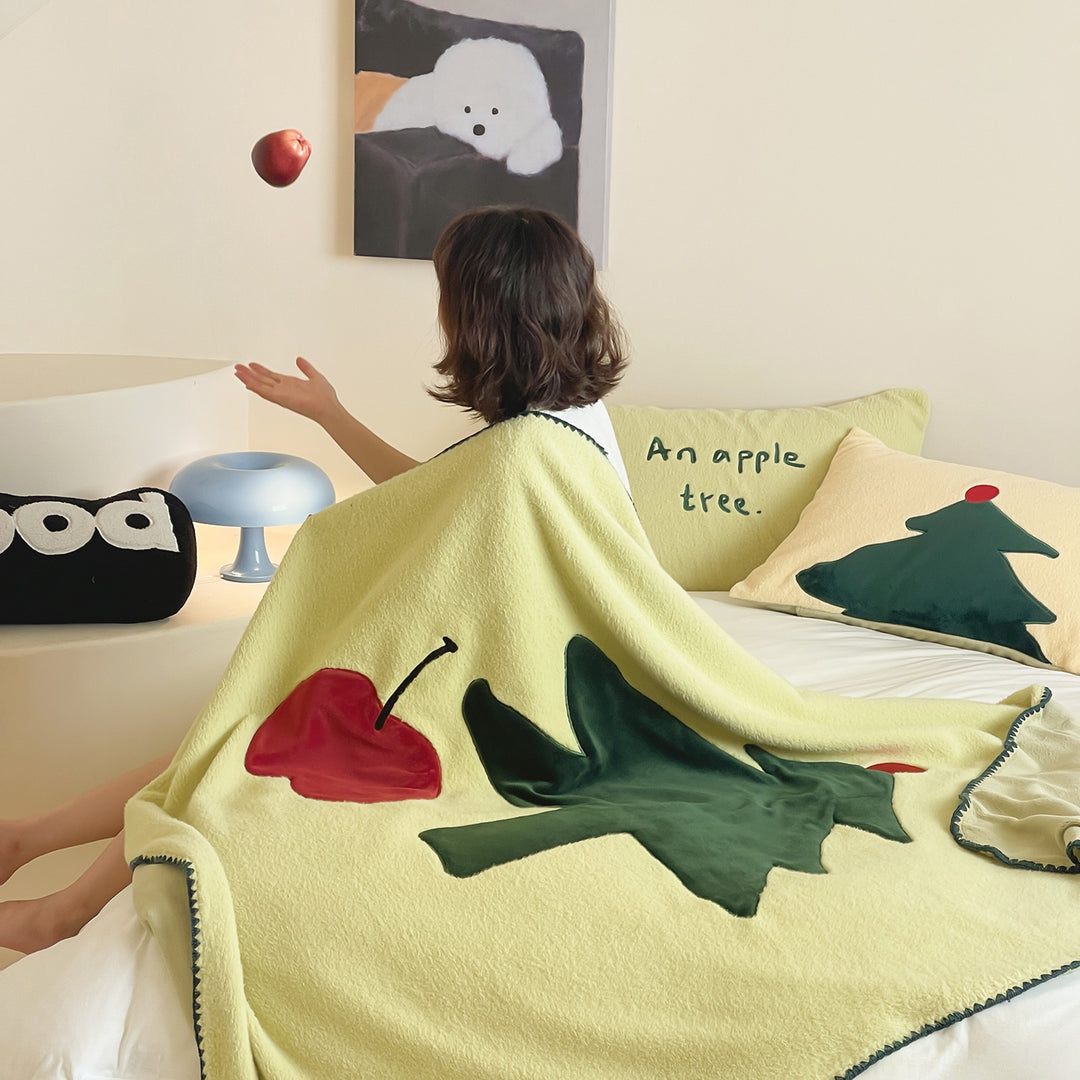 Kuschelige Wendefleece-Tagesdecke mit appliziertem Tannenbaum- und Apfelmotiv