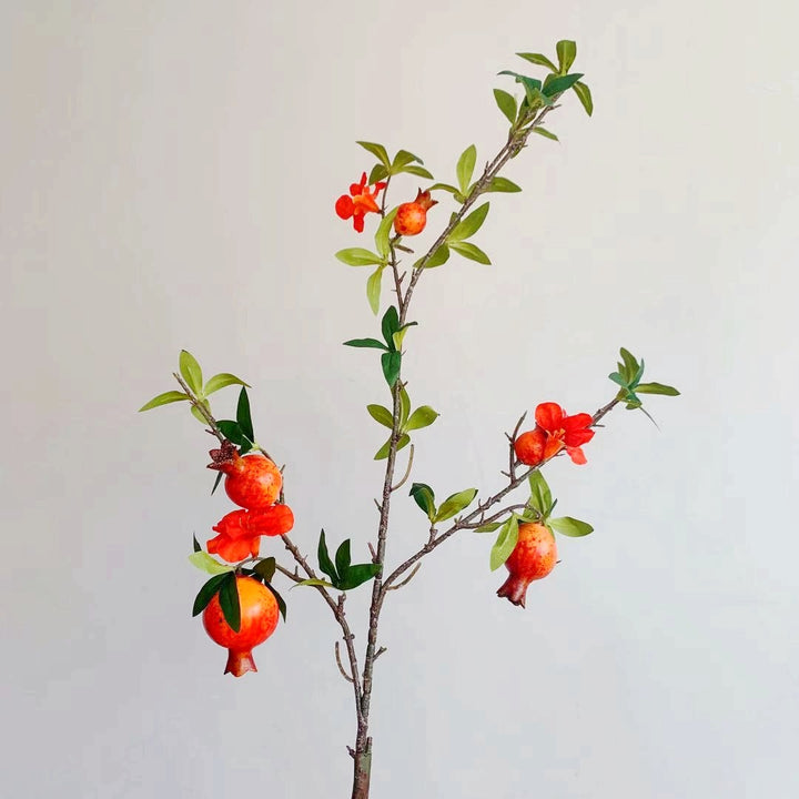 Dekorativer Granatapfel und Blumenzweig