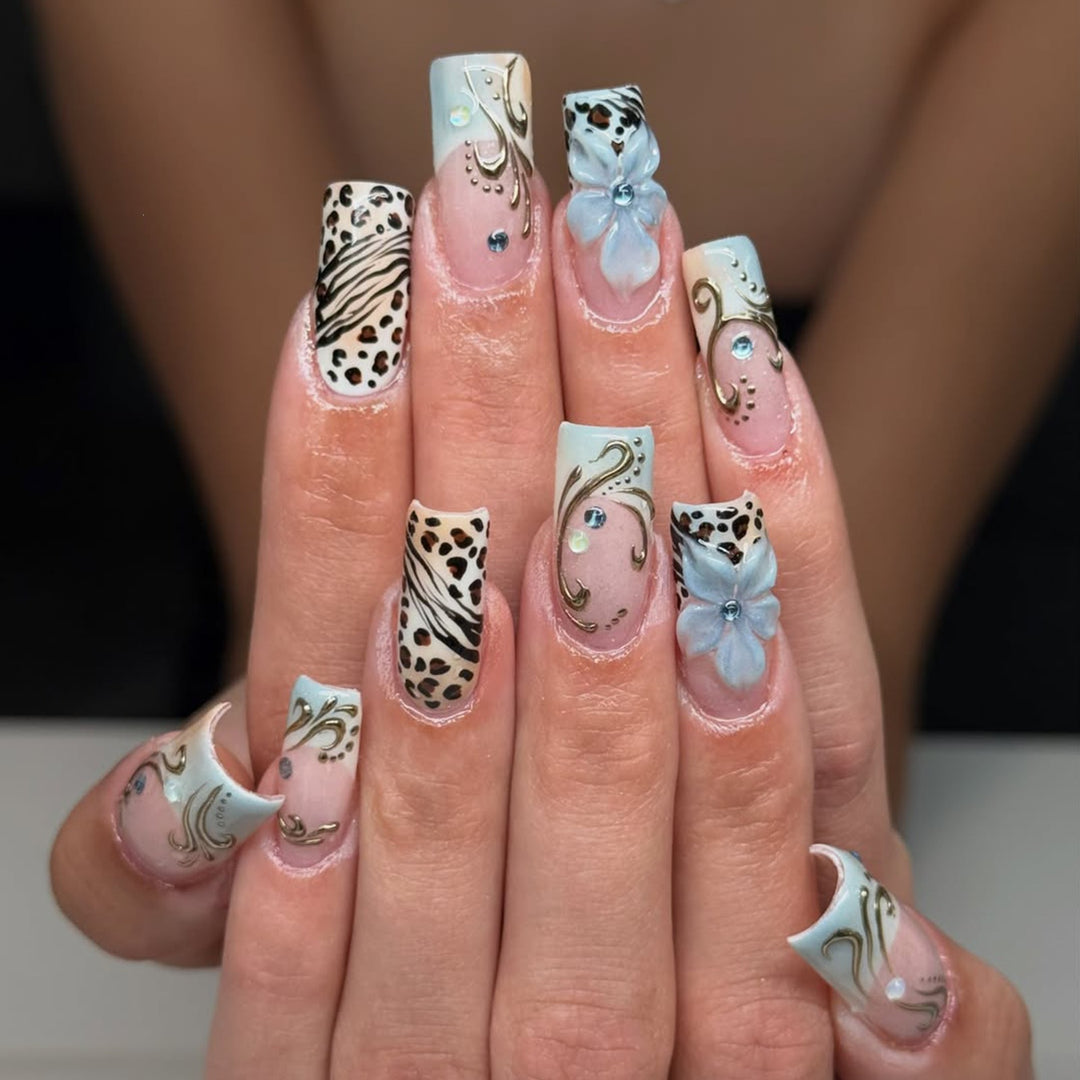 Glamouröses Kunstnagelset mit floralen Akzenten und Glitzerdetails Karnz