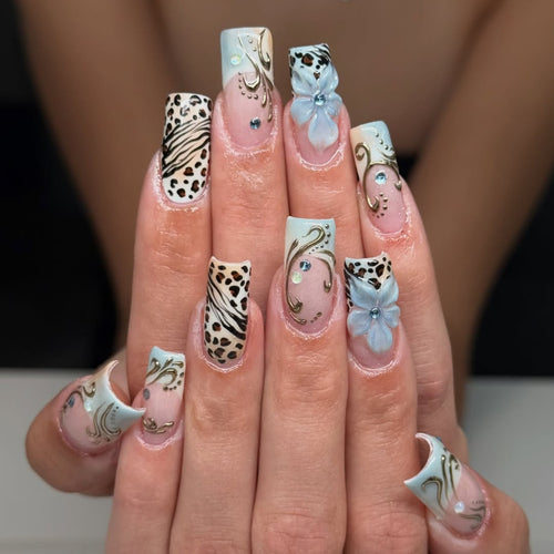 Glamouröses Kunstnagelset mit floralen Akzenten und Glitzerdetails Karnz