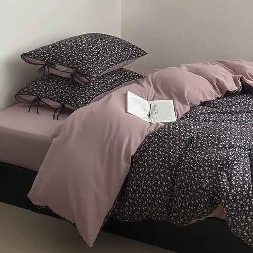 Wendbare Bettwäsche‑Garnitur aus Baumwollsatin mit feinem Blumenallover, kontrastierter Innenseite und dekorativen Schleifen