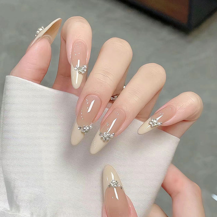 Kunstnagelset mit eleganten Spitzen und funkelnden Applikationen Karnz