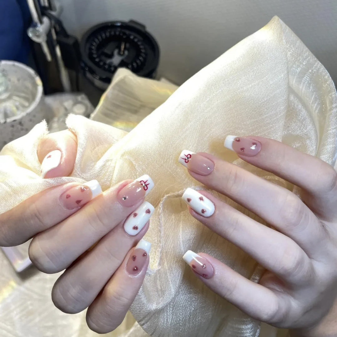 Dekorativer Press-On-Nagelset mit Herz- und Bogenmotiven