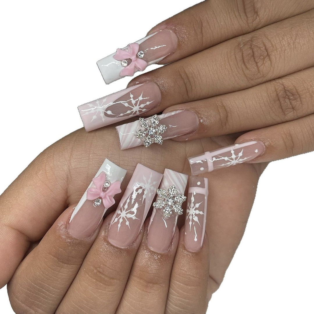 Kreatives Kunstnagelset mit filigranen Schneeflocken- und Schleifenverzierungen Karnz