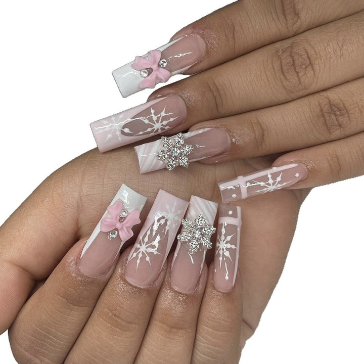 Kreatives Kunstnagelset mit filigranen Schneeflocken- und Schleifenverzierungen Karnz