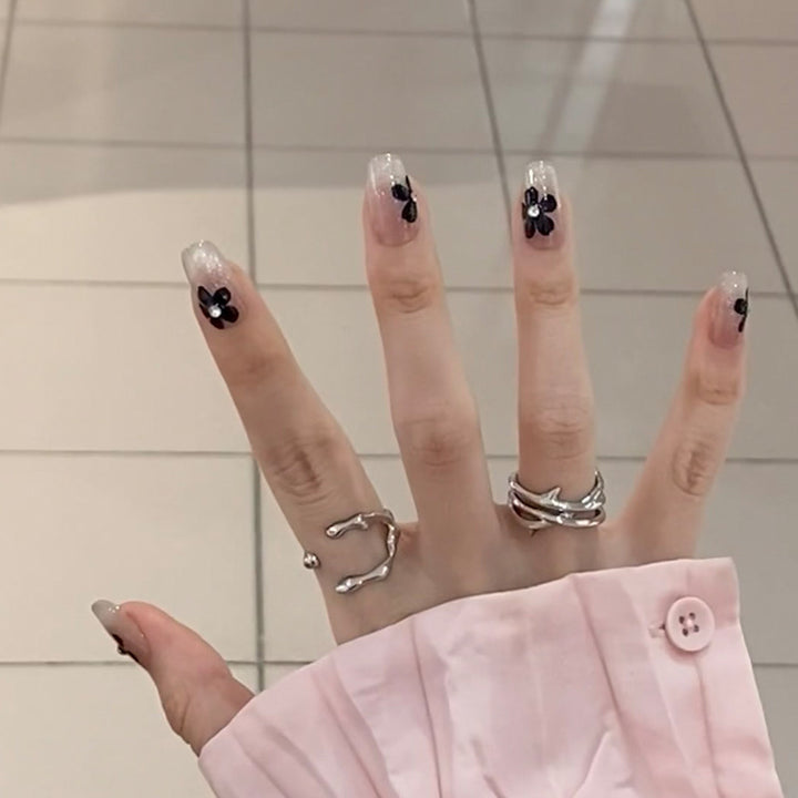 Kunstnagelset mit elegantem Blumendesign und glamourösen Akzenten Karnz