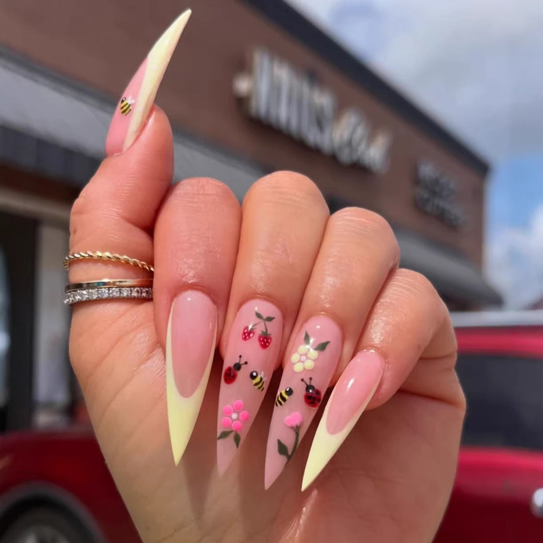 Kunstnagelset mit buntem Frühlingsdesign und eleganten Spitzen Karnz