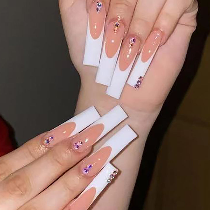 Kunstnagelset mit eleganten French-Spitzen und funkelnden Strassverzierungen Karnz