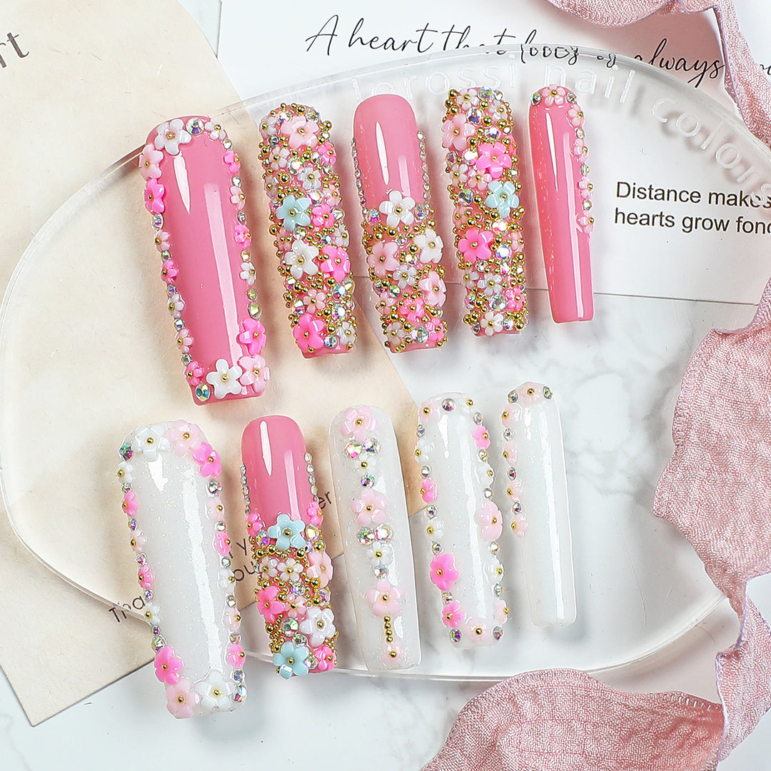 Kunstnagelset mit floralen Verzierungen und Glitzerakzenten Karnz