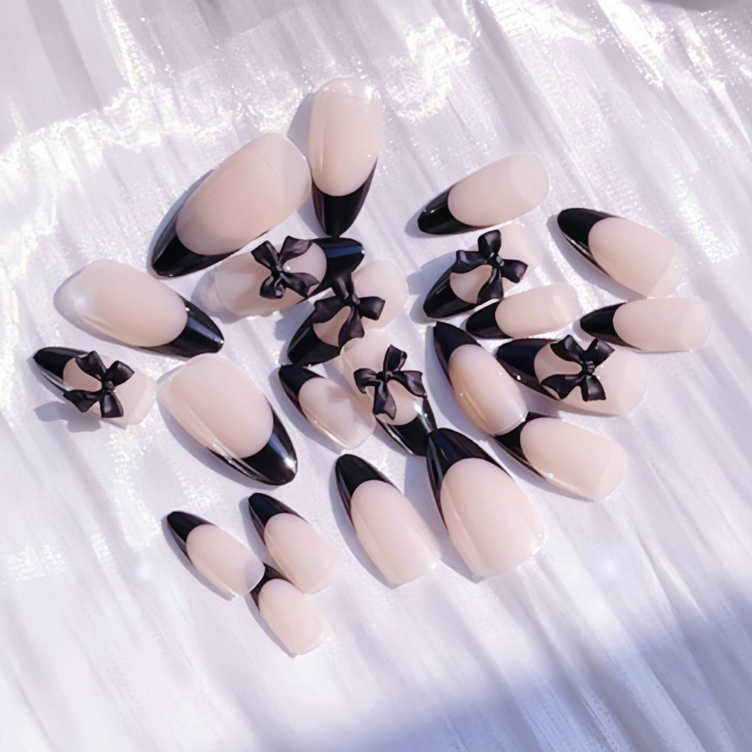 Künstlerisches Stiletto Press-On Nageldesign mit Schleifenakzenten Karnz