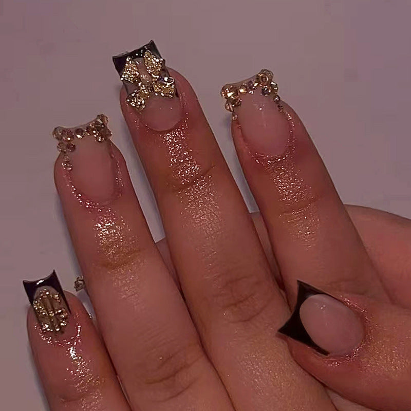 Kunstnagelset mit eleganten goldenen Verzierungen und modernem Design Karnz
