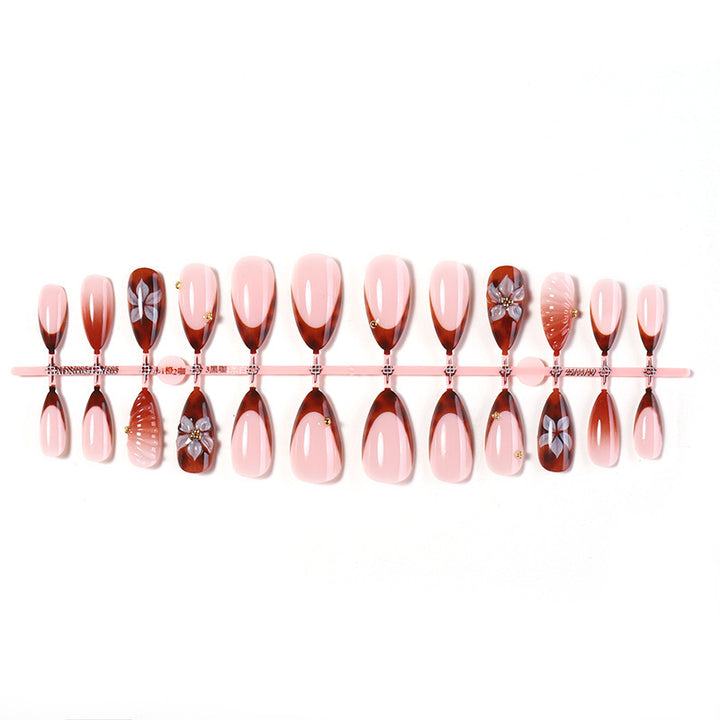 Kunstnagelset mit detailliertem Ombre-Design und kreativen Blütenakzenten Karnz